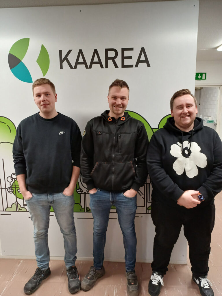 Arttu Nieminen, Mikael Söderholm ja Oliver Nikkilä seisovat Kaarean logon edessä Kaarean kiinteistöpalvelujen toimistolla.