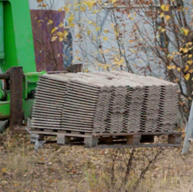 Kuvassa ehjänä puretut kattotiilet pinottuna kuormalavan päälle